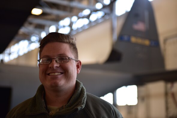 A man wearing the Airman Battle Uniform stands in front of a C-130J.