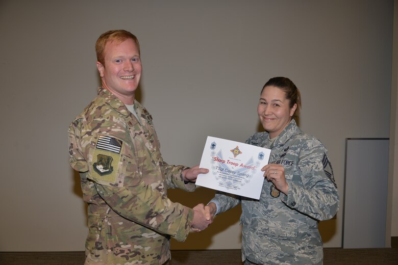 Tech. Sgt. Casey Spang, 71st Special Operations Squadron CV-22 evaluator special mission aviator, is receives a sharp troop award from Chief Master Sgt. Kristina Haley, Air Force Inspection Agency, at Kirtland, Nov. 8, 2018. Spang performs in-flight examinations for instructor and student aircrews, certifying their ability to safely accomplish the mission. Spang was recognized for above and beyond efforts in training and evaluating students, including a monthly average of 18 hours of in-flight instruction. (U.S. Air Force photo by Todd Berenger)