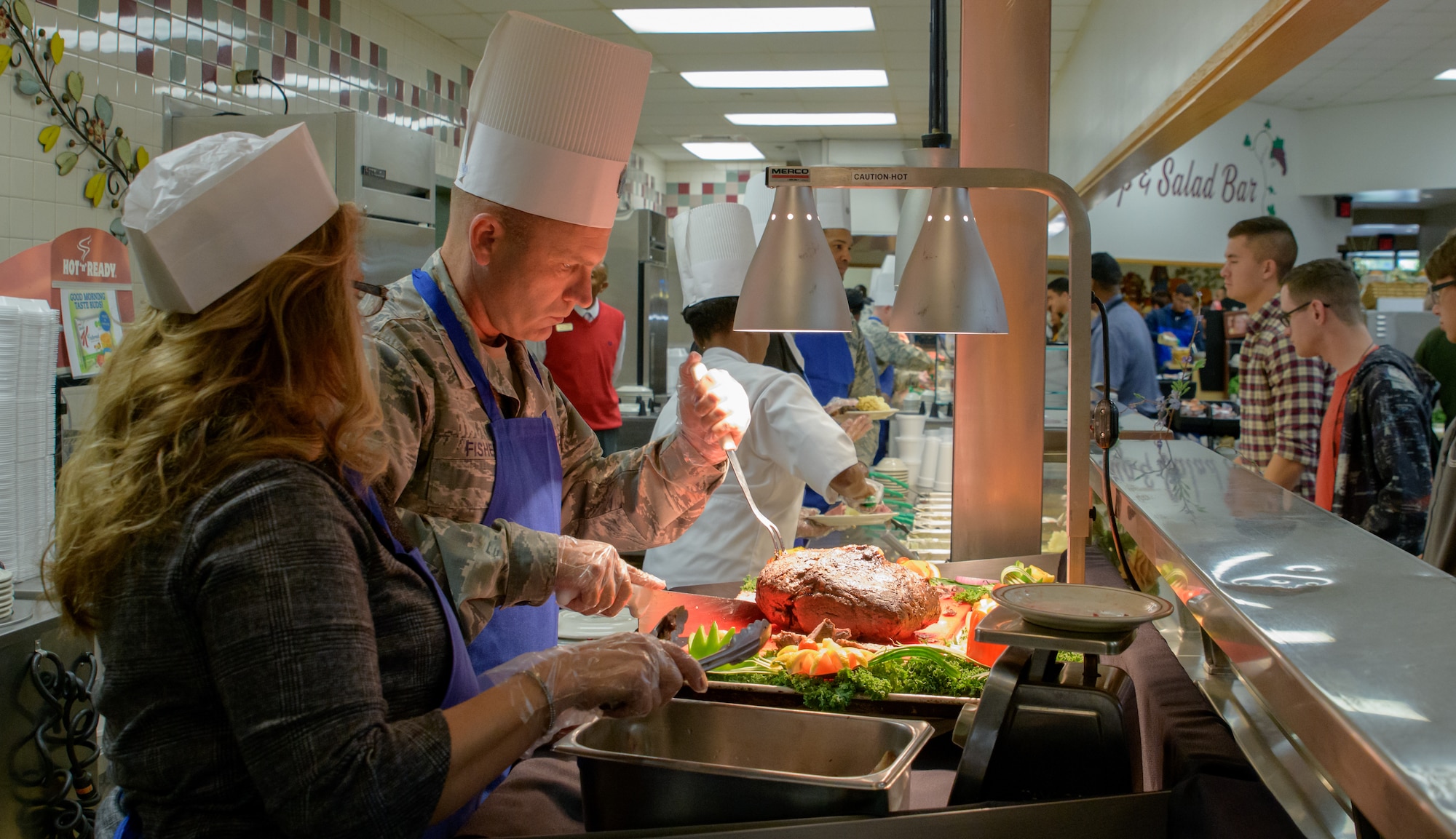 U.S. Air Force Chief Master Sgt. Anthony J. Fisher, 81st Training Group superintendent, and his wife, Holly, serve Thanksgiving Day lunch to service members inside the Azalea Dining Facility at Keesler Air Force Base, Mississippi, 22 Nov. 2018. It is tradition at Keesler for commanders, first sergeants and superintendents to take time out of their holiday to serve a Thanksgiving meal at the dining facilities to technical training and permanent party Airmen. (U.S. Air Force photo by Andre' Askew)