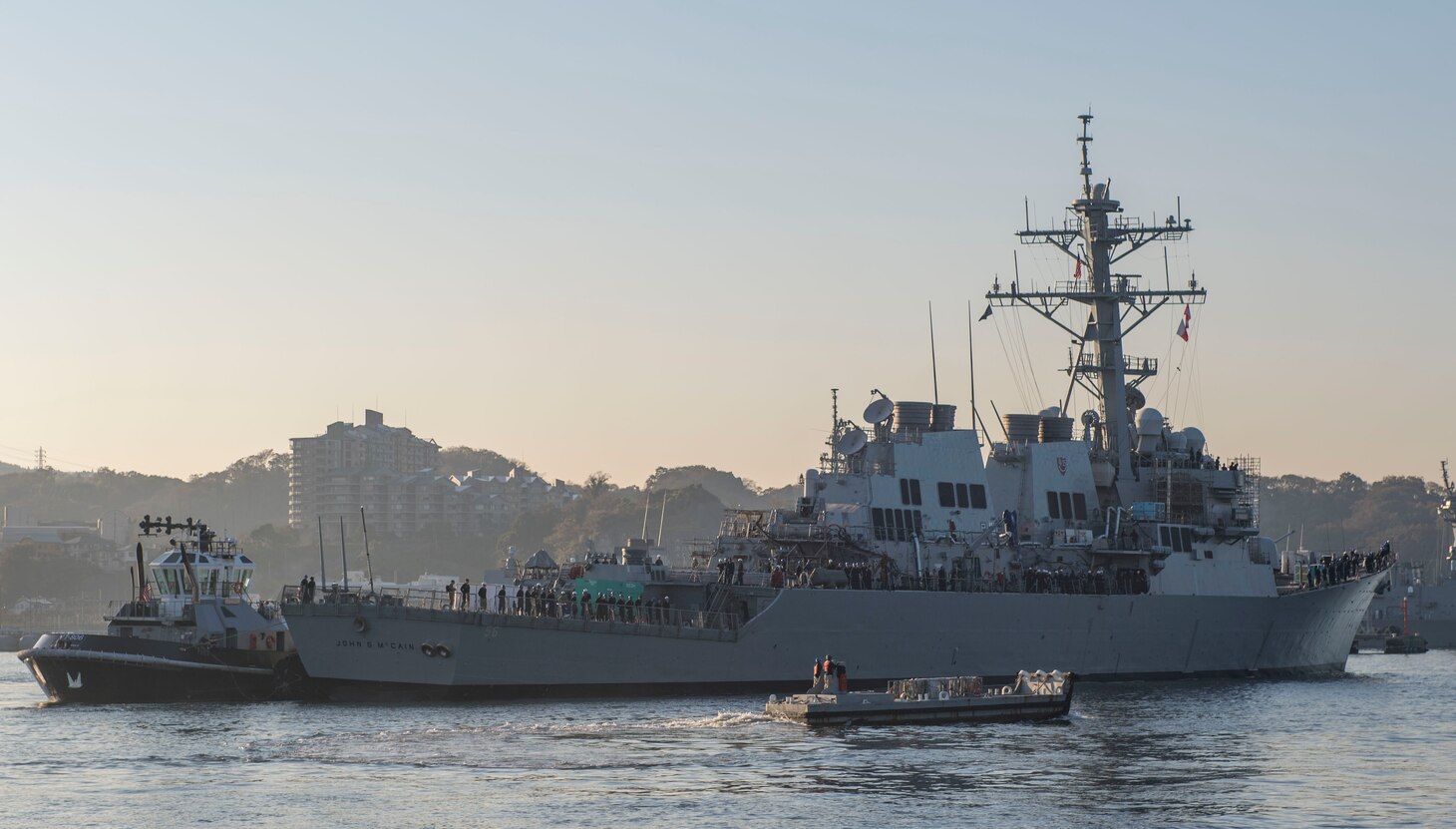 YOKOSUKA, Japan (Nov. 27, 2018) The Arleigh Burke-class guided missile destroyer USS John S. McCain (DDG 56) is pulled towards a pier after departing from a dry dock at Fleet Activities Yokosuka. McCain is departing the dock after an extensive maintenance period in order to sustain the ship's ability to serve as a forward-deployed asset in the U.S. 7th Fleet area of operations. (U.S. Navy Photo by Mass Communication Specialist 2nd Class Jeremy Graham)