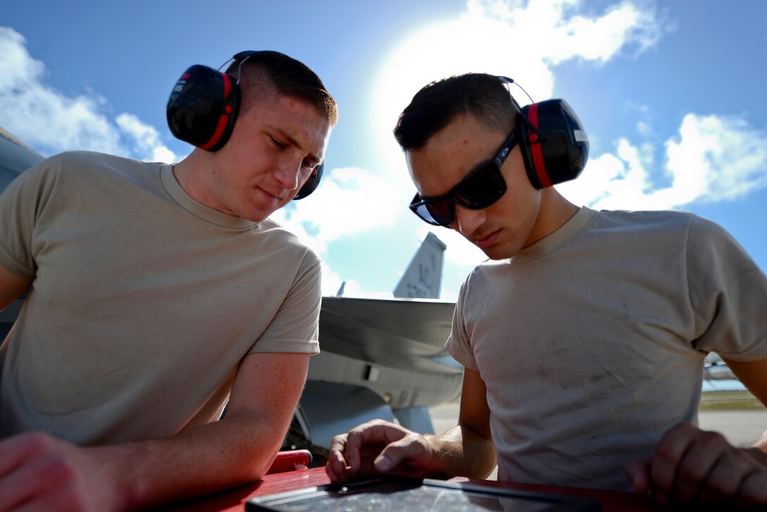 A picture of U.S. Air Force Airman 1st Class Robert Burkett and Senior Airman Leon Nable, with the 177th Fighter Wing electrical and bioenvironmental shop, using an electronic technical order to troubleshoot a pressure connection in an F-16C Fighting Falcon.