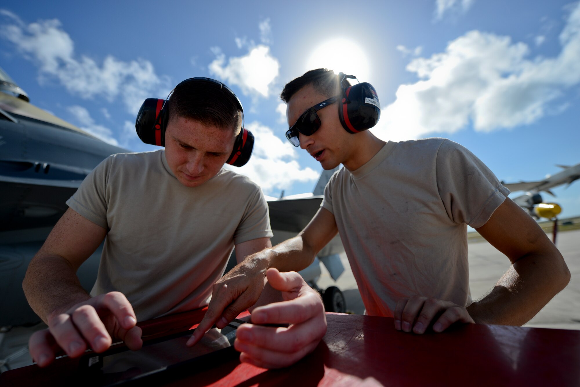 A picture of U.S. Air Force Airman 1st Class Robert Burkett and Senior Airman Leon Nable, with the 177th Fighter Wing electrical and bioenvironmental shop, using an electronic technical order to troubleshoot a pressure connection in an F-16C Fighting Falcon.
