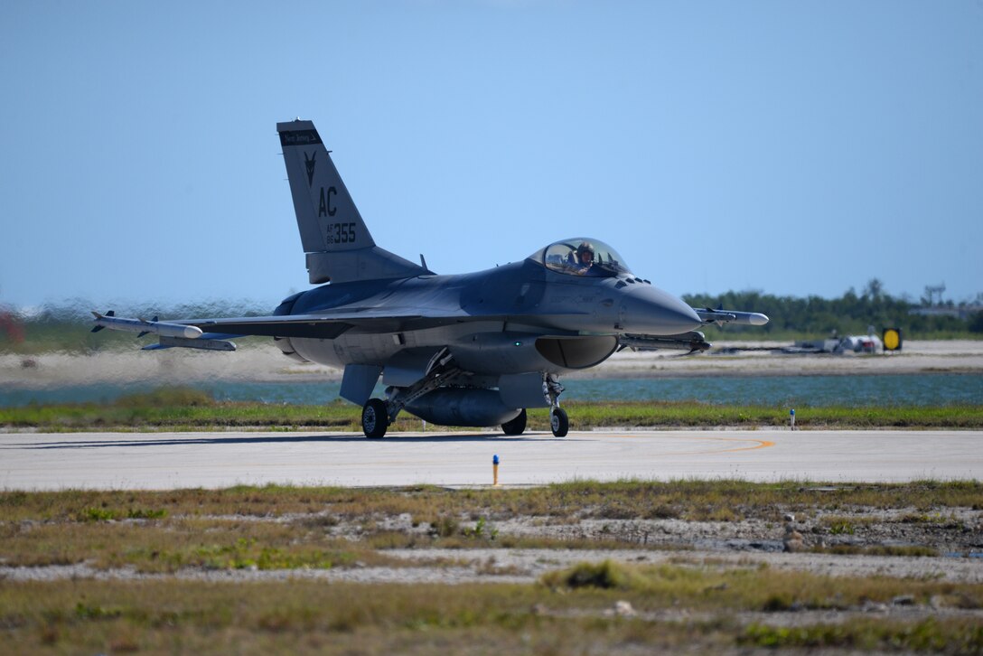 A picture of a U.S. Air Force F-16C Fighting Falcon taxiing towards an active runway.