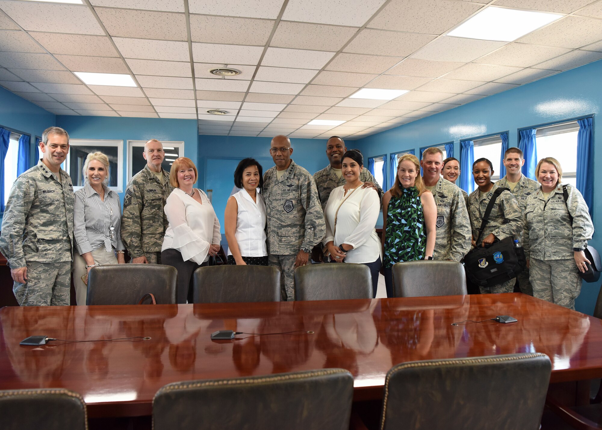 (Left to right) Lt. Gen. Kenneth Wilsbach, Seventh Air Force commander, his wife Cindy, Chief Master Sgt. Scott Lumpkin, Seventh Air Force command chief, his wife Meg, Gen. CQ Brown, Jr., Pacific Air Forces commander, his wife Sharene, Chief Master Sgt. Anthony Johnson, Pacific Air Forces command chief, his wife Stephanie, Lt. Gen. Thomas Bergeson, former Seventh Air Force commander, his wife Pamela, Capt. Lisa Gund, Seventh Air Force aide-de-camp, Brig. Gen. Lance Pilch, Seventh Air Force deputy commander, and Maj. Megan Mallone, 607th Air Operations Center legal advisor, pose for a photo inside a UNC Military Armistice Committee conference room at the Joint Security Area August 26, 2018. The room sits on top of the demarcation line, meaning the group is technically standing inside the Democratic People’s Republic of Korea. (U.S. Air Force photo by Airman 1st Class Ilyana Escalona)