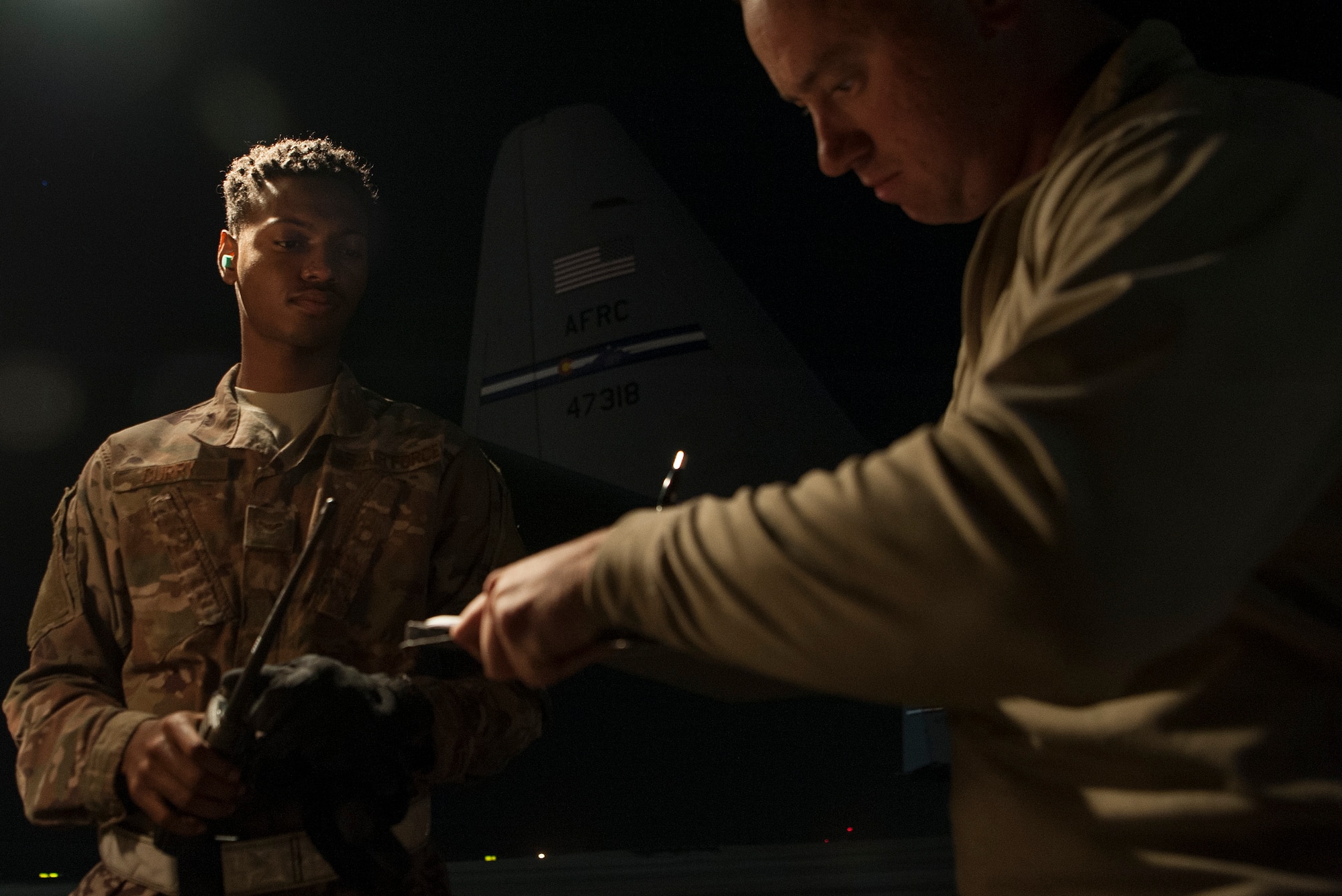 Airman 1st Class Christen Curry, left, 379th Expeditionary Logistics Readiness Squadron fuels distribution operator, fills out paperwork with an aircrew member during the refueling of a C-130 Hercules Nov. 28, 2018, at Al Udeid Air Base, Qatar.