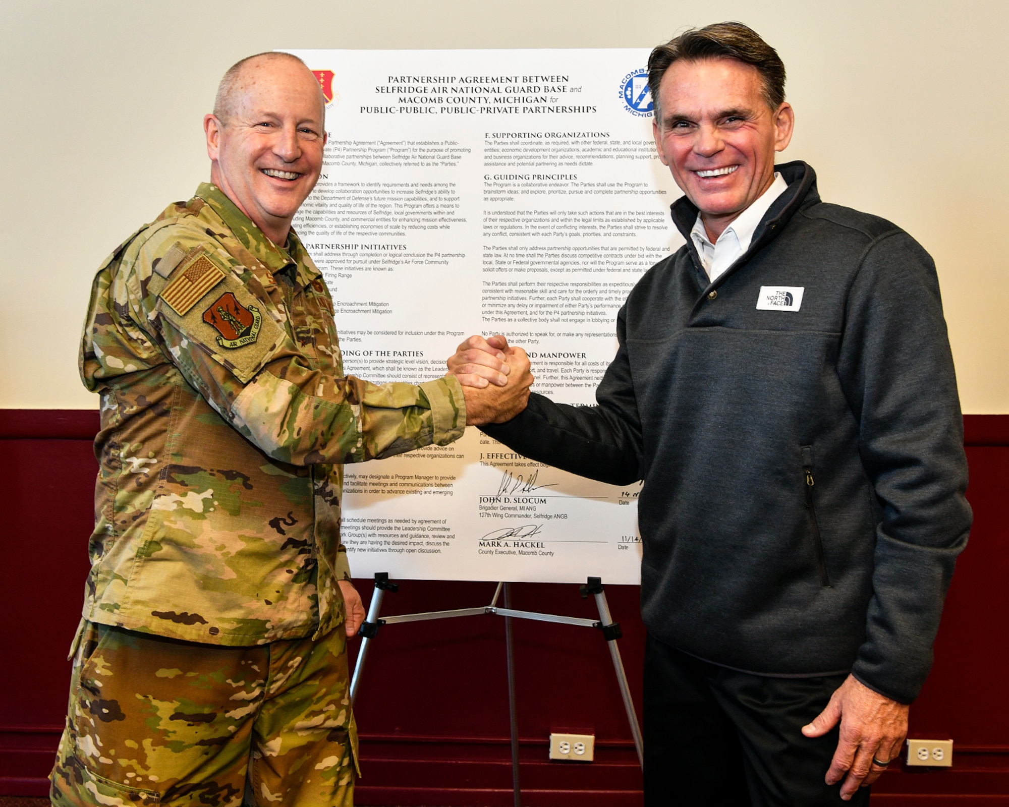 Brig. Gen. John D. Slocum, commander of Selfridge Air National Guard Base and the 127th Wing, and Macomb County Commissioner Mark Hackel, celebrate the 44th tenant organization joining the Team Selfridge Community after a key-passing ceremony here on November 14, 2018.