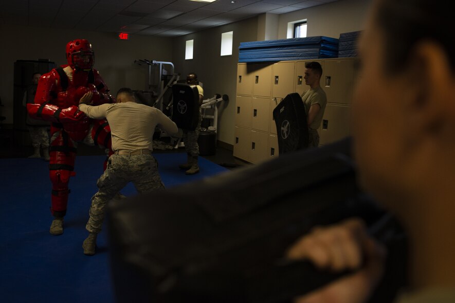 Senior Airman Darien Gunter, 375th Security Forces Squadron patrolman, performs strike techniques against a simulated aggressor during baton training at Scott Air Force Base, Illinois on Nov. 19, 2018. Each defender must successfully complete a fight with the “redman” while demonstrating proper technique before being certified on the baton. (U.S. Air Force photo by Senior Airman Daniel Garcia)