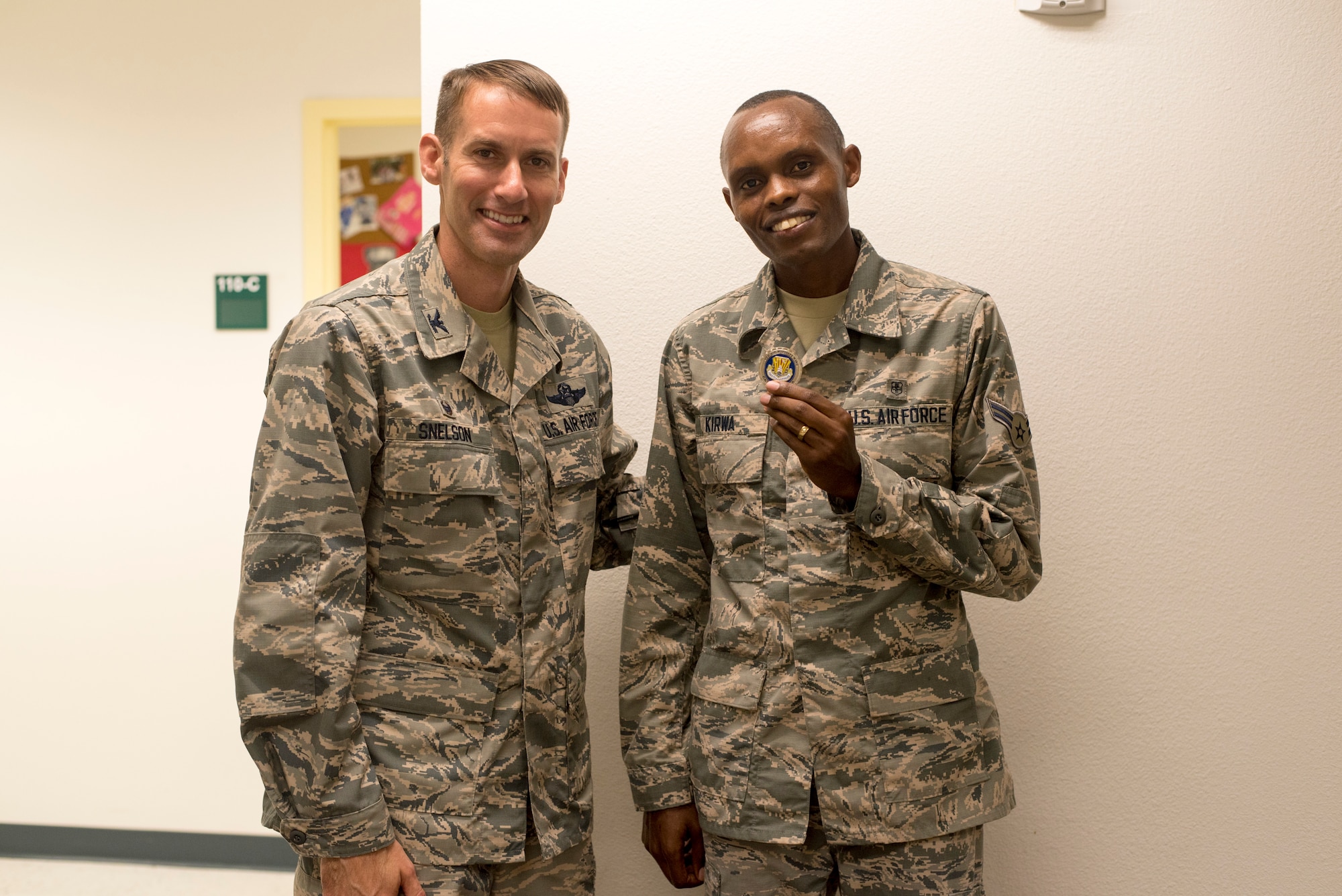 U.S. Air Force Col. Stephen Snelson, 6th Air Mobility Wing Commander, coins U.S. Air Force Airman 1st Class Daniel Kirwa, an aerospace medical technician assigned to the 6th Medical Operations Support Squadron, at MacDill Air Force Base's Brandon clinic, Fla., Oct. 11, 2018