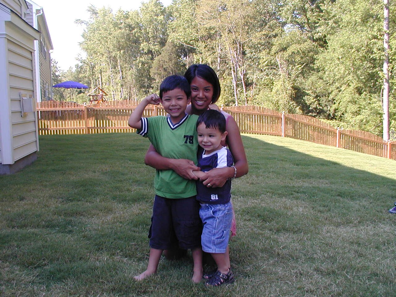 Woman and her two sons pose in backyard