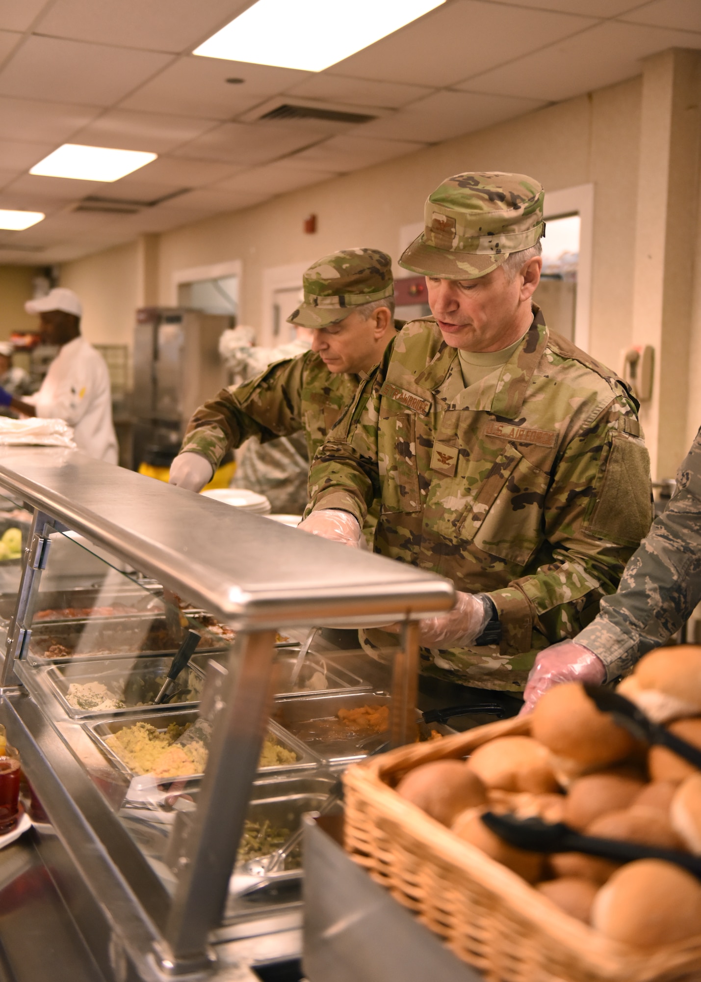 Col. Douglas N. Strawbridge, commander of the 911th Airlift Wing, and Command Chief Master Sgt. Christopher D. Neitzel, command chief of the 911th Airlift, serve food to Airmen at a Thanksgiving lunch at the Pittsburgh International Airport Air Reserve Station, Pennsylvania, Nov. 3, 2018. Every year the base leadership serve a Thanksgiving lunch to give thanks to the Airmen on the base. (U.S. Air Force photo by Senior Airman Grace Thomson)