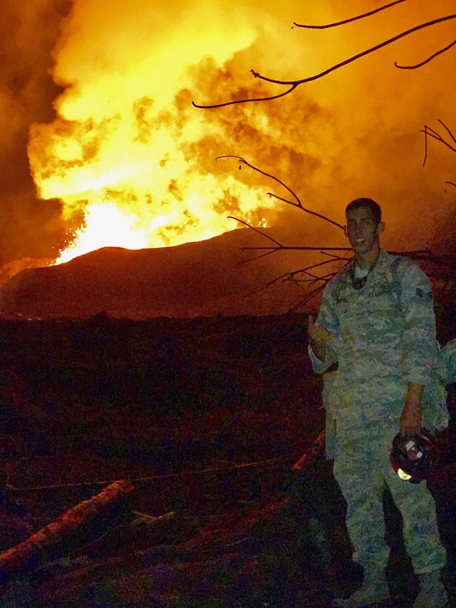 Senior Airman Casey Whitworth, 154th Medical Group Detachment 1 response team member, observes a lava fissure during a volcano outbreak June 11, 2018 in near Leilani Estates, Hawaii.