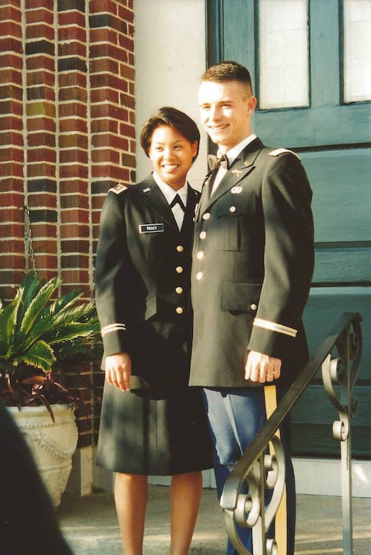 Man and woman pose on Army uniforms on steps