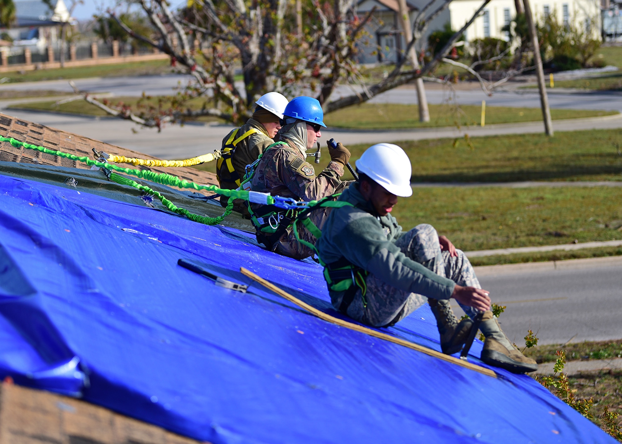 From left to right, Senior Airman Jake Stauffer and Airmen 1st Class Marc Karns and Ikiem Williams, members of Task Force Phoenix, repair a damaged rooftop at Tyndall Air Force Base, Fla., Nov. 28, 2018. Task Force Phoenix is responsible for large-scale clean up and reconstruction after Hurricane Michael ravaged Tyndall Air Force Base and the panhandle of Florida. (U.S. Air Force photo by Senior Airman Isaiah J. Soliz)