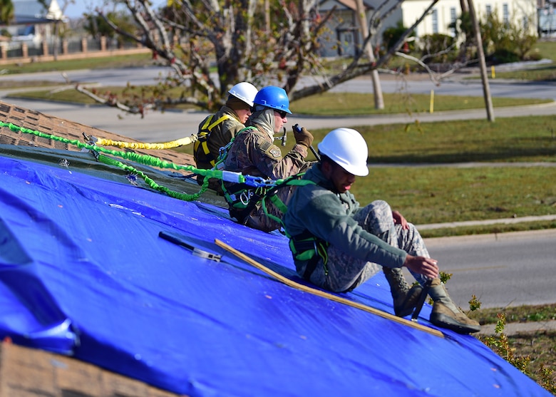 From left to right, Senior Airman Jake Stauffer and Airmen 1st Class Marc Karns and Ikiem Williams, members of Task Force Phoenix, repair a damaged rooftop at Tyndall Air Force Base, Fla., Nov. 28, 2018. Task Force Phoenix is responsible for large-scale clean up and reconstruction after Hurricane Michael ravaged Tyndall Air Force Base and the panhandle of Florida. (U.S. Air Force photo by Senior Airman Isaiah J. Soliz)