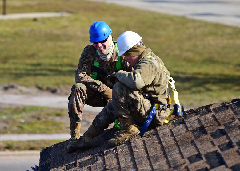 Task Force Phoenix members Airman 1st Class Marc Karns, left, and Senior Airman Jake Stauffer, right, pause for a moment while repairing a damaged rooftop at Tyndall Air Force Base, Fla., Nov. 28, 2018. Task Force Phoenix is tasked with large-scale cleanup and reconstruction of the base in the wake of Hurricane Michael. (U.S. Air Force photo by Senior Airman Isaiah J. Soliz)