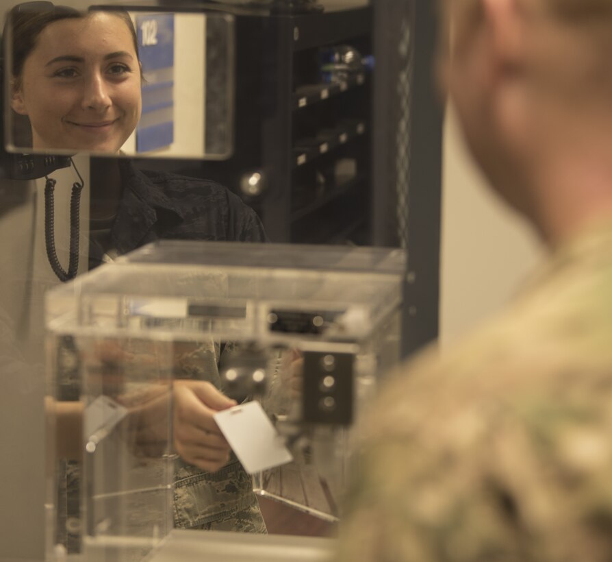 U.S. Air Force Senior Airman Charlotte Stenzel, 60th Air Mobility Wing Command Post emergency actions controller, provides a visitor pass Nov. 21, 2018, at Travis Air Force Base, California. The command post is in a secure location due to the types of information that they can receive, such as operational reports and their ability to track every flight that comes in and out of the base. (U.S. Air Force photo by Staff Sgt. Amber Carter)