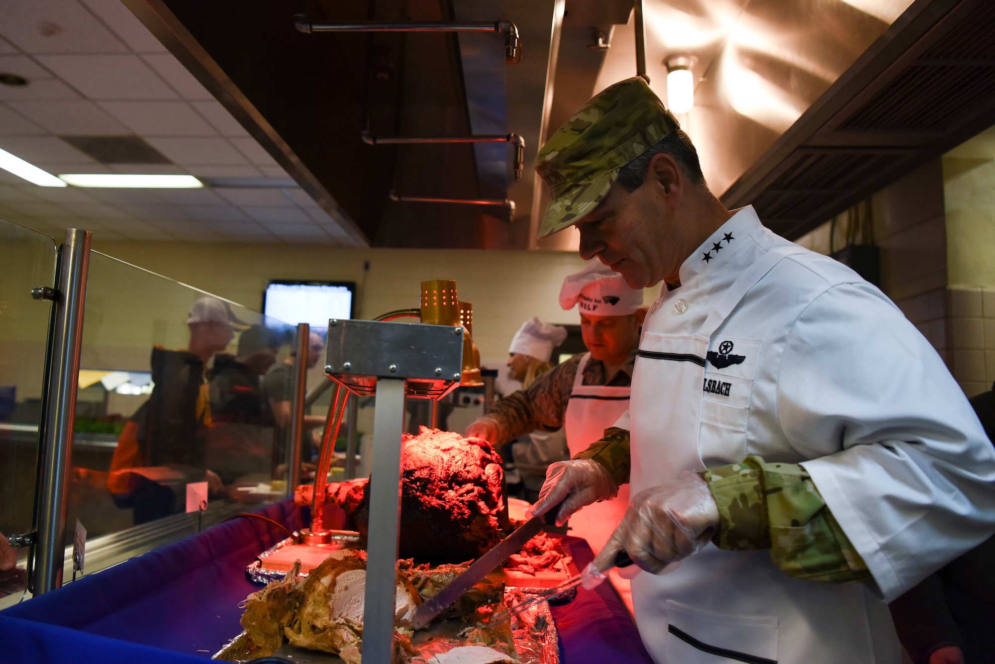 U.S. Air Force Lt. Gen. Kenneth Wilsbach, Seventh Air Force commander, carves a turkey at Kunsan Air Base, Republic of Korea, Nov. 22, 2018. Gen. Wilsbach, his wife, Cynthia, and other Seventh Air Force leadership joined base leadership as they prepared and served a Thanksgiving meal to Airmen. (U.S. Air Force photo by Senior Airman Savannah L. Waters)