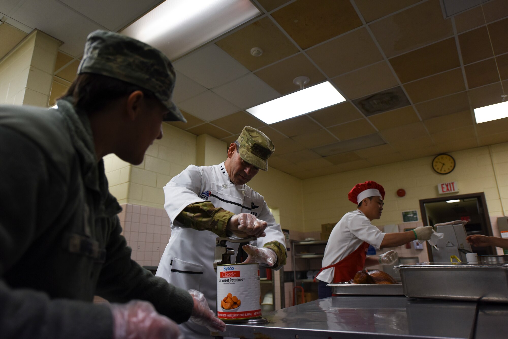 U.S. Air Force Lt. Gen. Kenneth Wilsbach, Seventh Air Force commander, opens a can of potatoes on Thanksgiving at Kunsan Air Base, Republic of Korea, Nov. 22, 2018. Gen. Wilsbach, his wife, Cynthia, and other members of Seventh Air Force leadership joined base leadership as they prepared and served a Thanksgiving meal to Airmen. (U.S. Air Force photo by Senior Airman Savannah L. Waters)