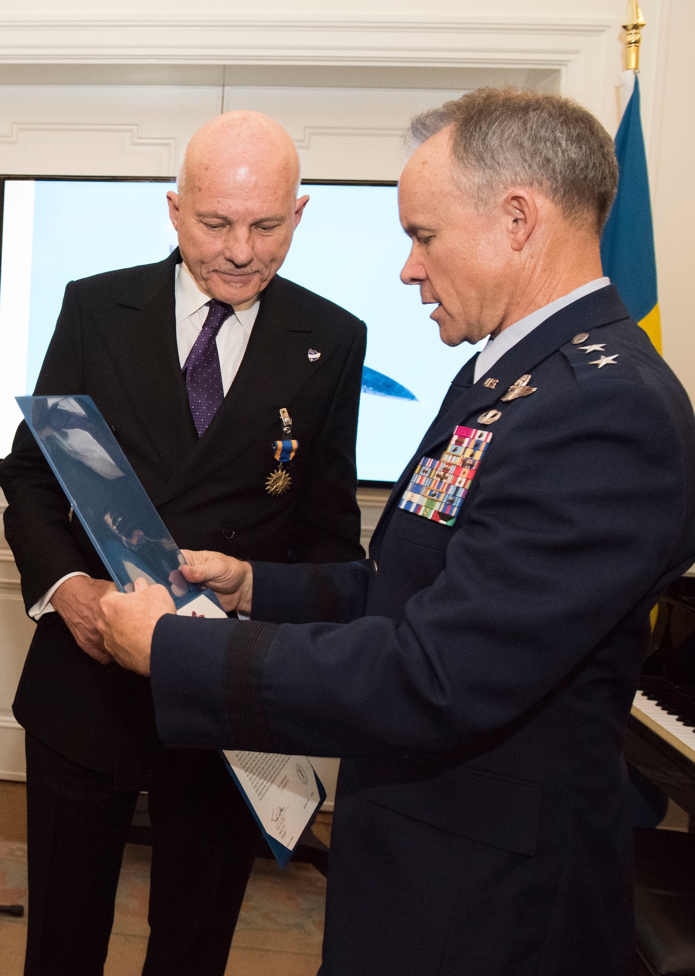 U.S. Air Force Maj. Gen. John Williams, Mobilization Assistant to the commander, U.S. Air Forces in Europe and Africa, presents the U.S. Air Medal to Swedish air force Maj. Krister Sjoberg in Stockholm, Sweden, Nov. 28, 2018. The Swedish pilots were awarded the U.S. Air Medal for their actions on June 29, 1987. (U.S. Air Force Photo by Senior Airman Kelly O'Connor)