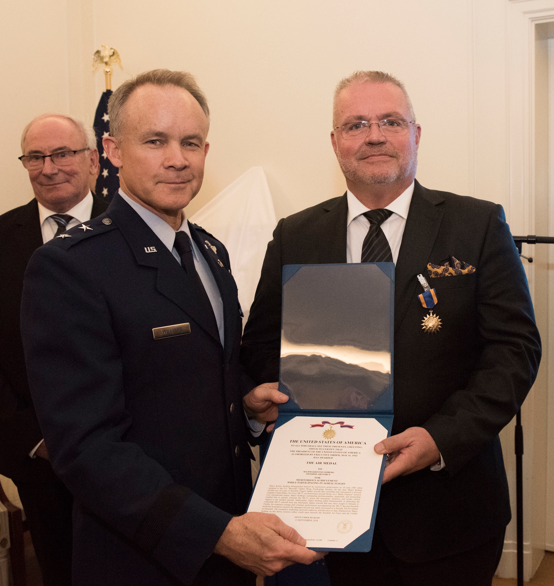 U.S. Air Force Maj. Gen. John Williams, Mobilization Assistant to the commander, U.S. Air Forces in Europe and Africa, presents the U.S. Air Medal to Swedish air force Maj. Roger Moller in Stockholm, Sweden, Nov. 28, 2018. The Swedish pilots were awarded the U.S. Air Medal for their actions on June 29, 1987. (U.S. Air Force Photo by Senior Airman Kelly O'Connor)