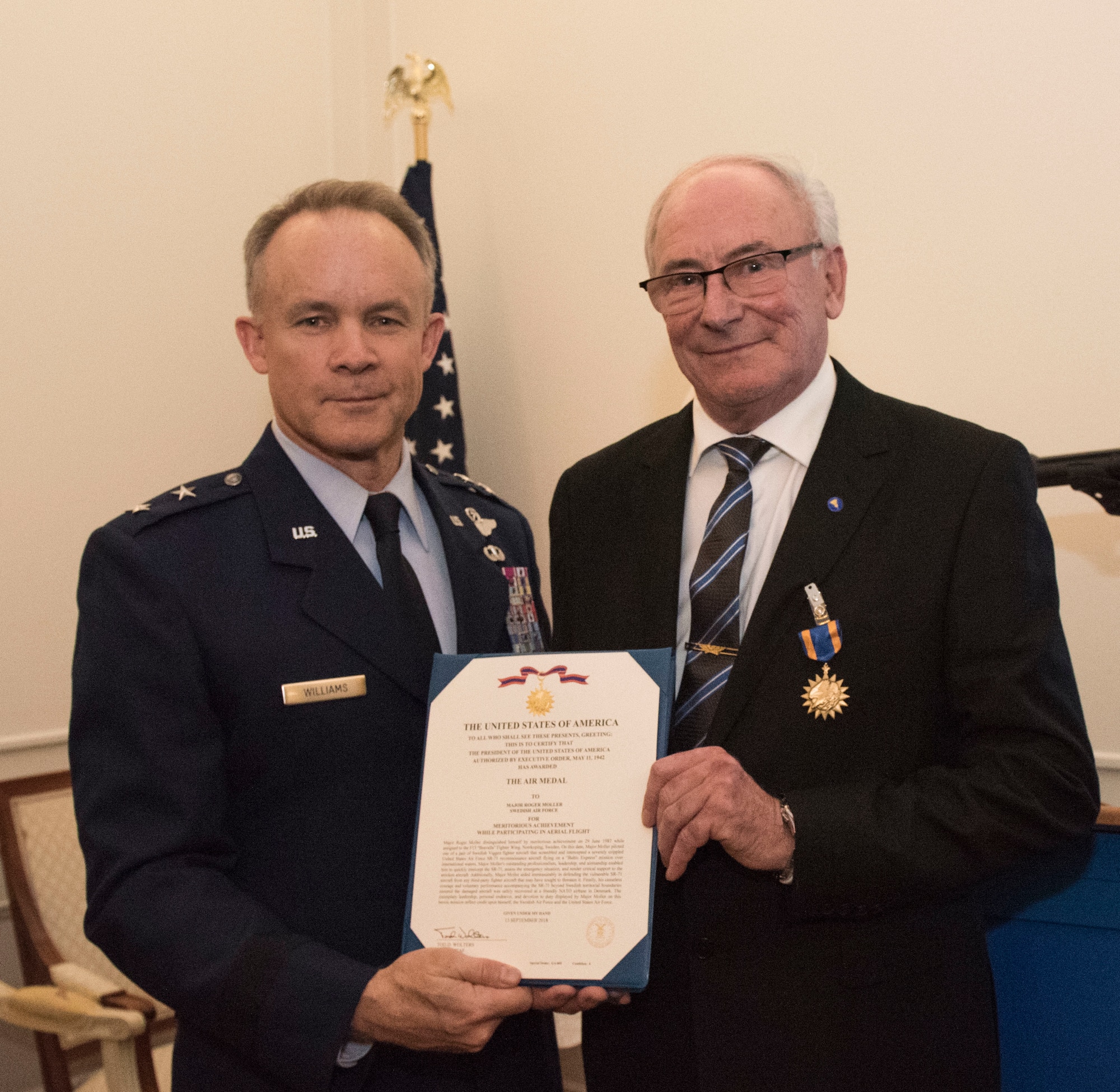 U.S. Air Force Maj. Gen. John Williams, Mobilization Assistant to the commander, U.S. Air Forces in Europe and Africa, presents the U.S. Air Medal to Swedish air force Col. Lars-Erik Blad in Stockholm, Sweden, Nov. 28, 2018. The Swedish pilots were awarded the U.S. Air Medal for their actions on June 29, 1987. (U.S. Air Force Photo by Senior Airman Kelly O'Connor)