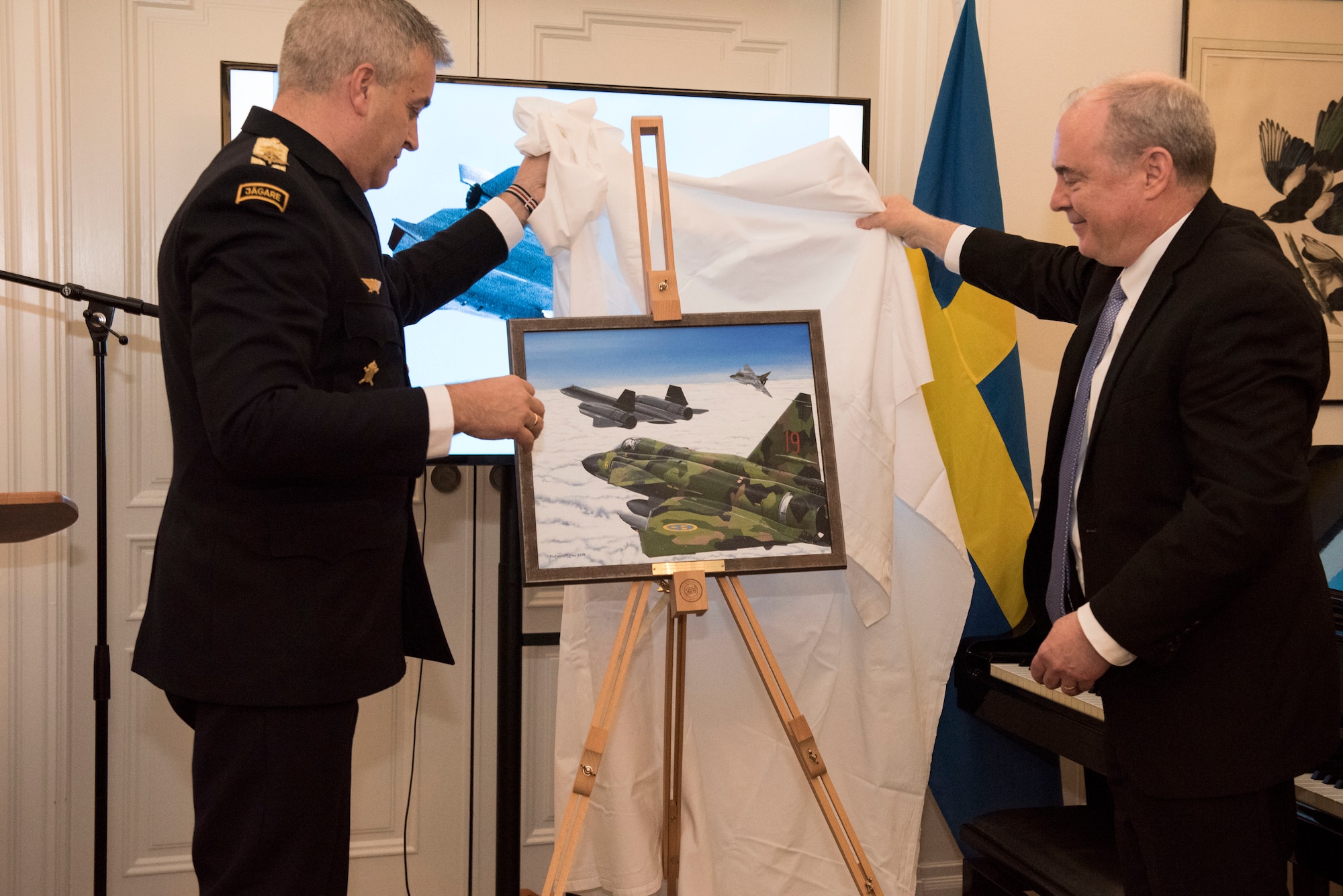Swedish and U.S. representatives unveil an official portrait of the event which distinguished the four Swedish pilots and earned them their U.S. Air Medals in Stockholm, Sweden, Nov. 28, 2018. The Swedish Airmen risked their lives to save an SR-71 and the aircrew on June 29, 1987. (U.S. Air Force Photo by Senior Airman Kelly O'Connor)