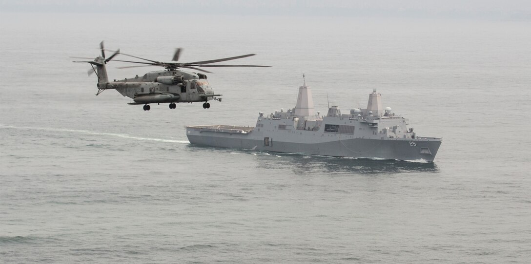 A U.S. Marine Corps CH-53E Super Stallion with Marine Heavy Helicopter Squadron 462, Special Purpose Marine Air-Ground Task Force - Peru, flies above the U.S. Navy San Antonio-class amphibious transport dock ship USS Somerset.