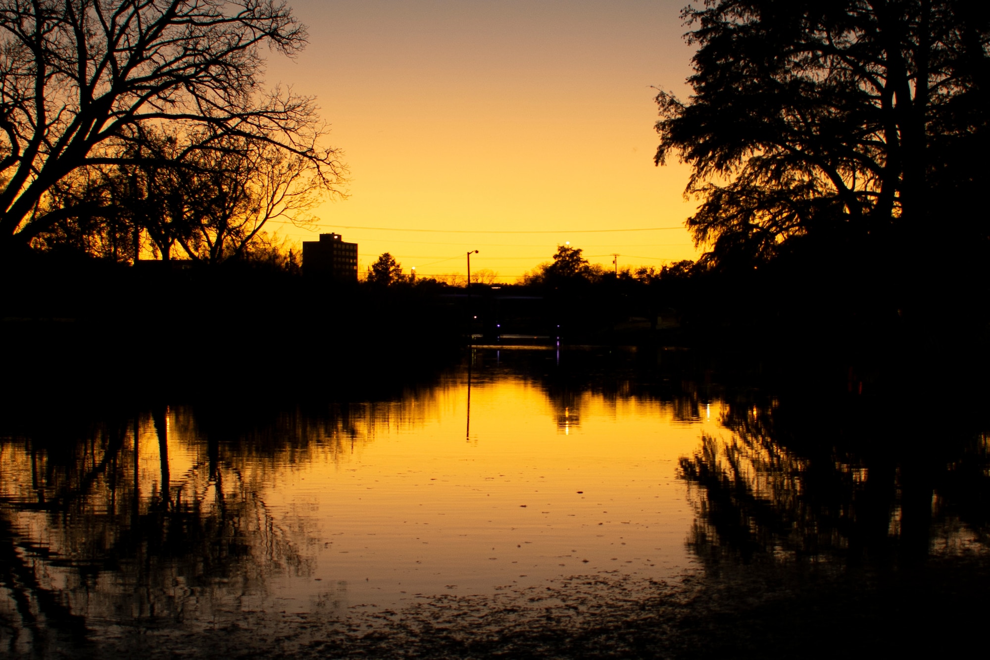 The sun sets over the Concho River in San Angelo, Texas, Nov. 28, 2018. The Mental Health Clinic mission is to provide the highest quality of care to the base population and the local community, across all branches of service, to promote mental health and provide appropriate support through prevention, education and treatment services. (U.S. Air Force photo by Senior Airman Randall Moose)