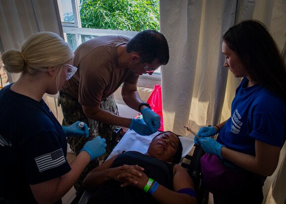 RIOHACHA, Colombia (Nov. 26, 2018) – Lt. Cmdr. Charles Sola (center), a dermatologist from Miami, Hospitalman Taylor Hart (left), from Dallas, and Alexandra Cortez, a volunteer from the U.S. embassy in Colombia, conduct a punch biopsy for a patient at one of two medical sites.
