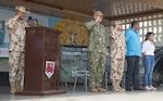 Capt. William Shafley (center), commander, Task Force 49, renders a salute during the playing of the National Anthem during the opening ceremony at one of two medical sites.