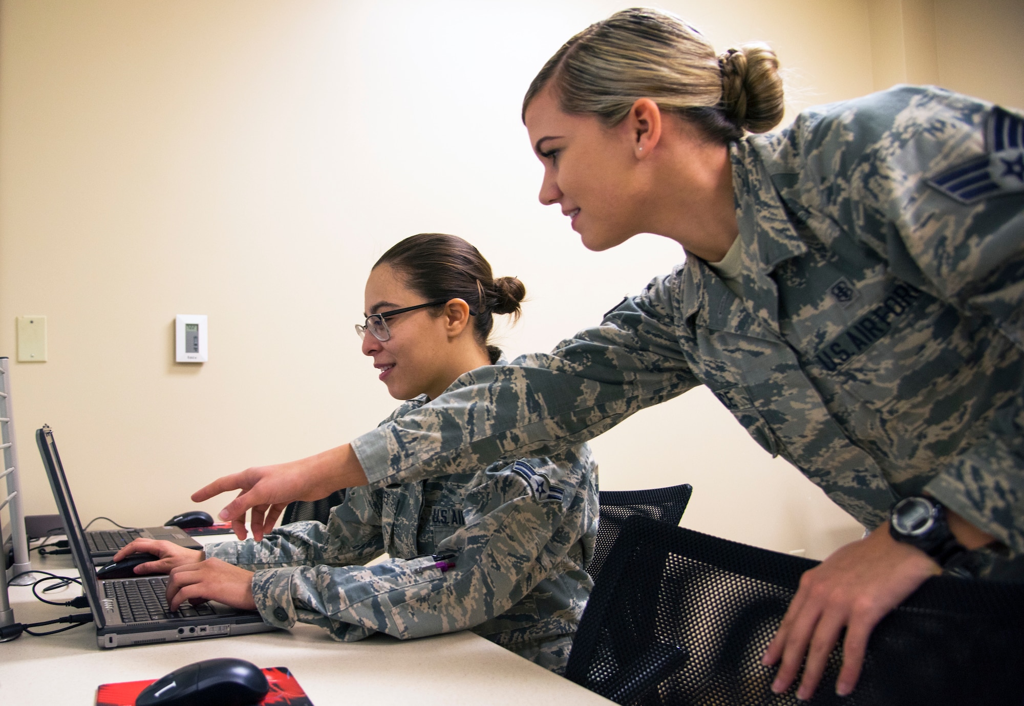 U.S. Air Force Senior Airman Amber Durrence, right, a 6th Medical Operations Squadron mental health technician, shows another Airman how to complete the mental health examination of their pre-deployment process at MacDill Air Force Base, Fla., Nov. 29, 2018.