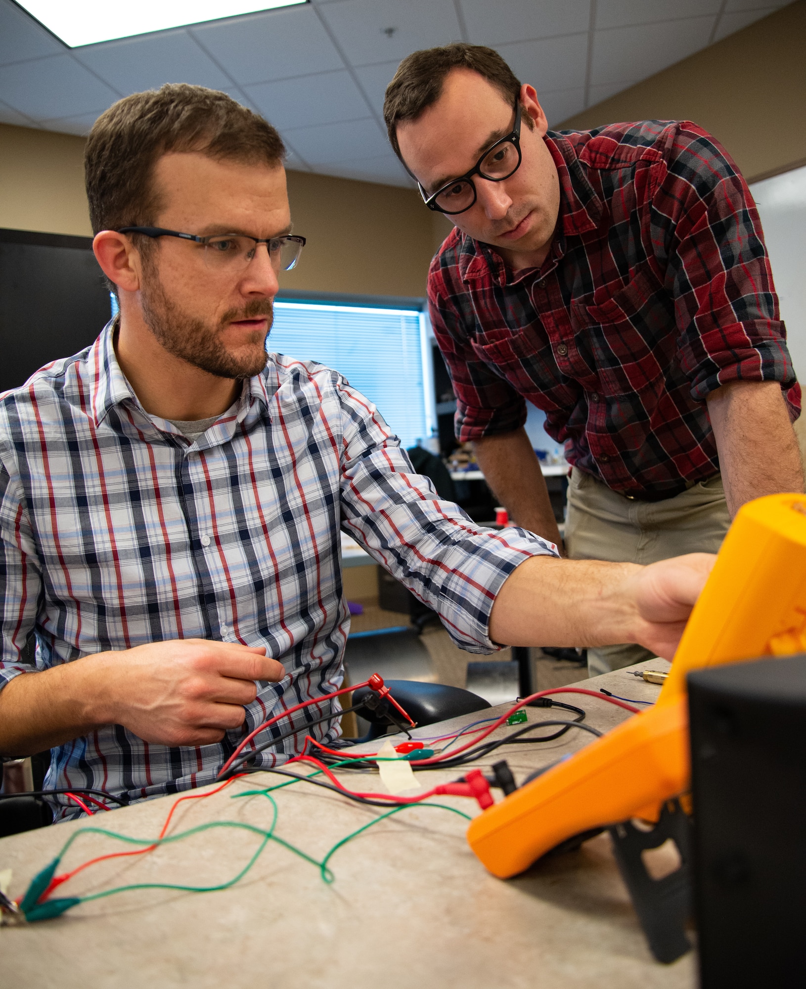 Joe Althaus, Wright Brothers Institute Rapid Innovation Program Manager (left), determines the power consumption of a piece of equipment as Isaac Weintraub, an electronics engineer with Air Force Research Laboratory's Aerospace Systems Directorate, observes during a rapid innovation session at AFRL's Maker Hub.