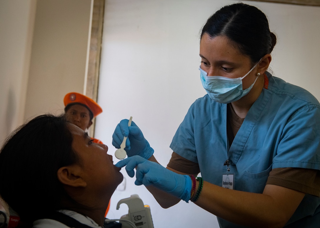 Honduran army Lt. Stephanie Arriaga, from Tegucigalpa, Honduras, conducts a dental exam for a patient at one of two medical sites.