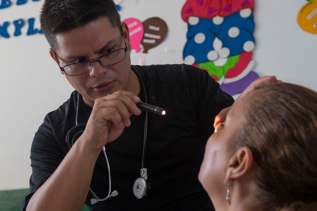 Walter Naira, a doctor in the Honduran navy, examines a patient for the general medicine department at one of two medical sites.