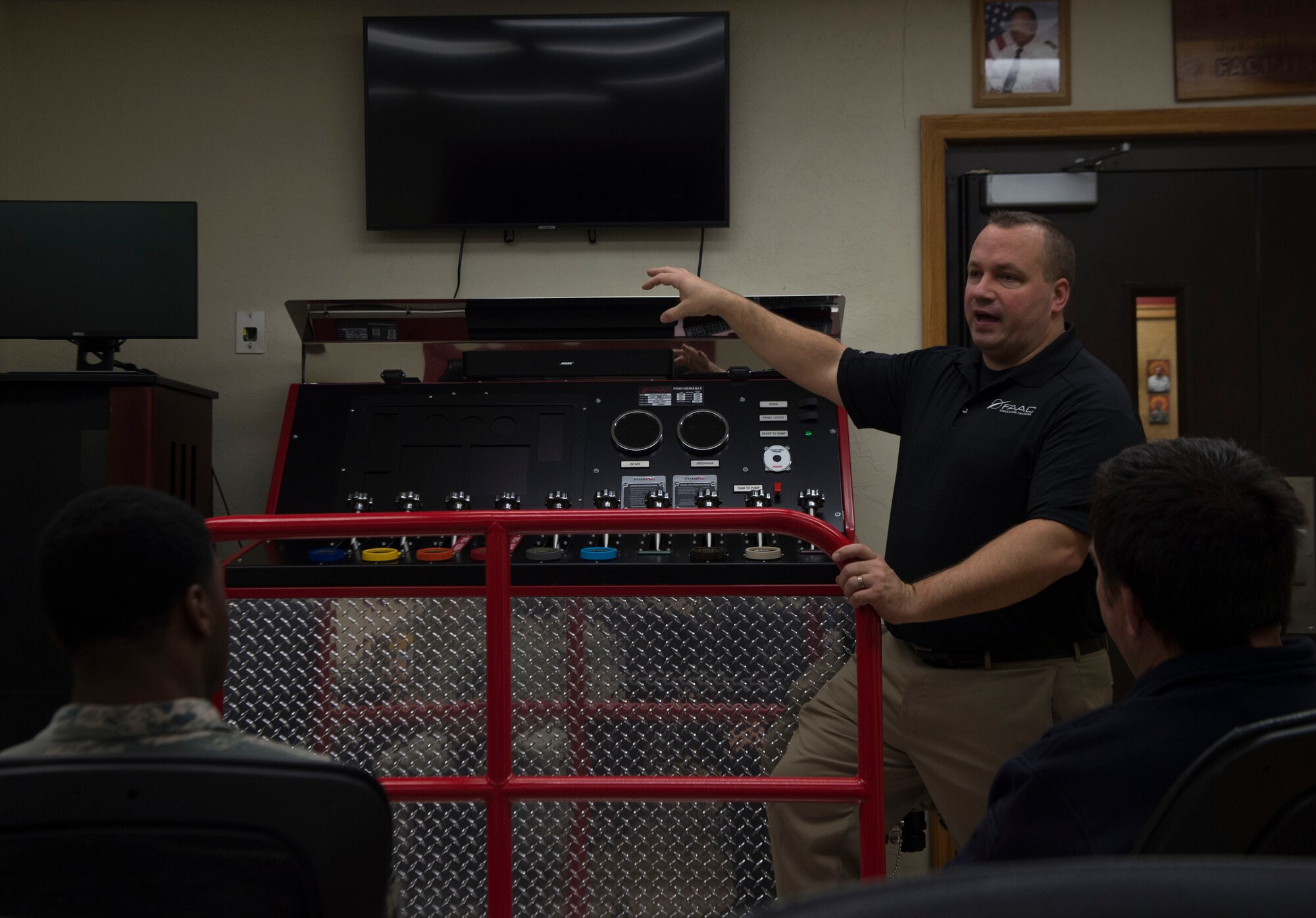 Phil Duczyminski, a subject matter specialist for FAAC, a firefighting simulation company, talks to the 97th Air Mobility Wing Fire Department about how to operate their new pump operations simulator, Nov. 20, 2018, Altus Air Force Base, Okla. This is one of three simulators the fire department is receiving to help make training easier and more efficient. (U.S. Air Force photo by Airman First Class Jeremy Wentworth)