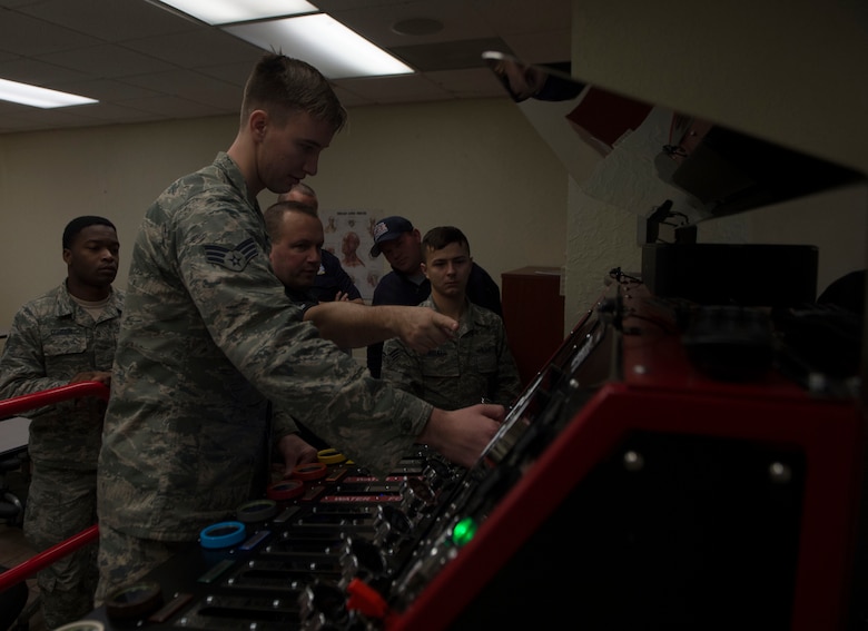 Firefighters assigned to the 97th Air Mobility Wing Fire Department practice on their new pump operations simulator, Nov. 20, 2018, Altus Air Force Base, Okla. The system is modeled to act and perform exactly like a 97th AMW fire truck pump operations system to allow for more efficient and accurate training. (U.S. Air Force photo by Airman First Class Jeremy Wentworth)