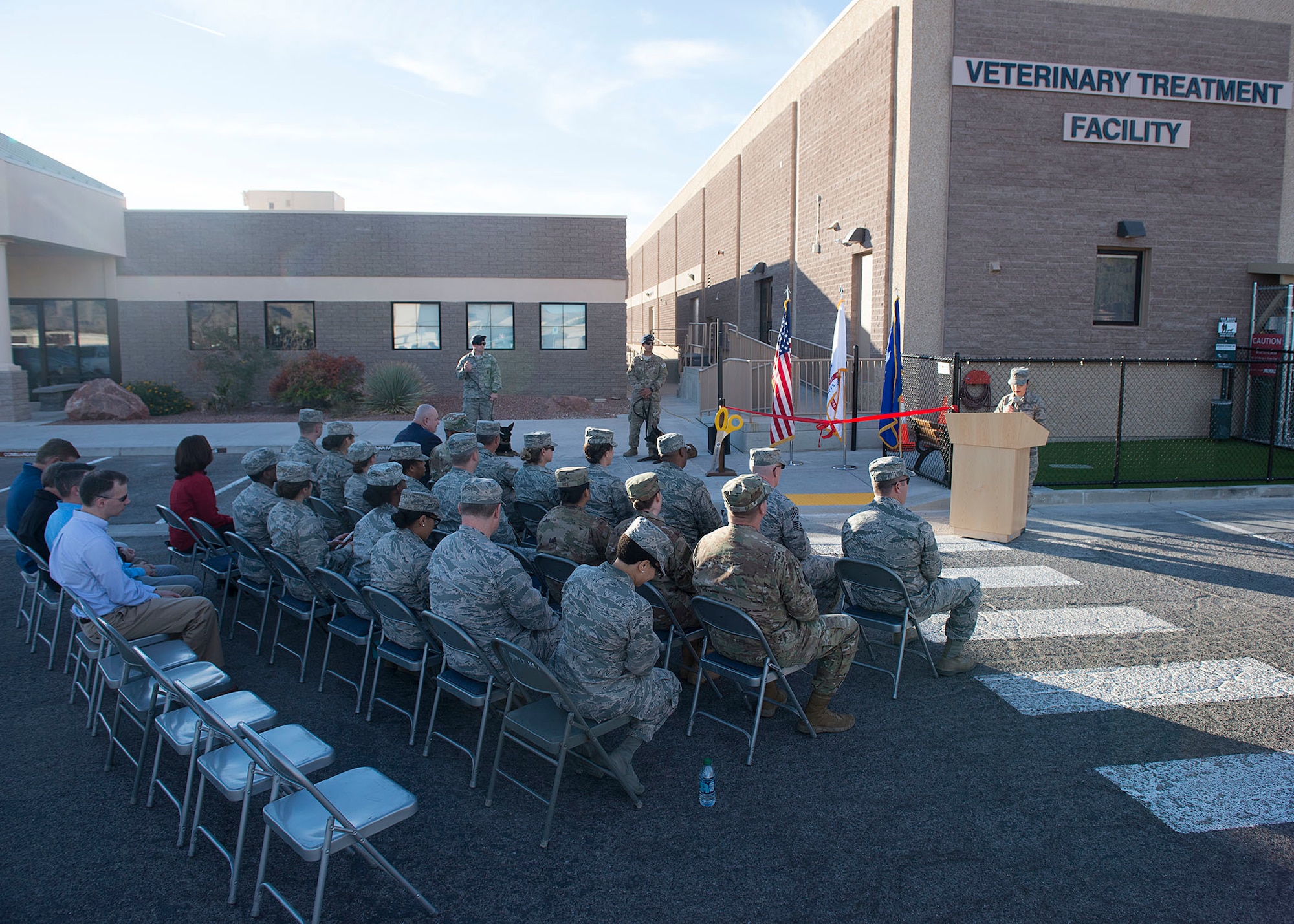 Base leadership, distinguished visitors and veterinary treatment facility staff cut the ribbon to signify the opening of the facility on Nellis Air Force Base, Nev., Nov. 14, 2018. The new facility is 3,600 square feet, which is twice the size of the previous facility. (U.S. Air Force photo by Airman 1st Class Bryan T. Guthrie)