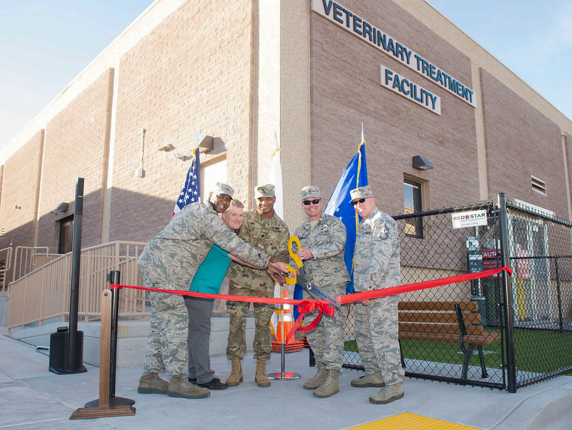 Base leadership, distinguished visitors and veterinary treatment facility staff cut the ribbon to signify the opening of the facility on Nellis Air Force Base, Nev., Nov. 14, 2018. The new facility is 3,600 square feet, which is twice the size of the previous facility. (U.S. Air Force photo by Airman 1st Class Bryan T. Guthrie)