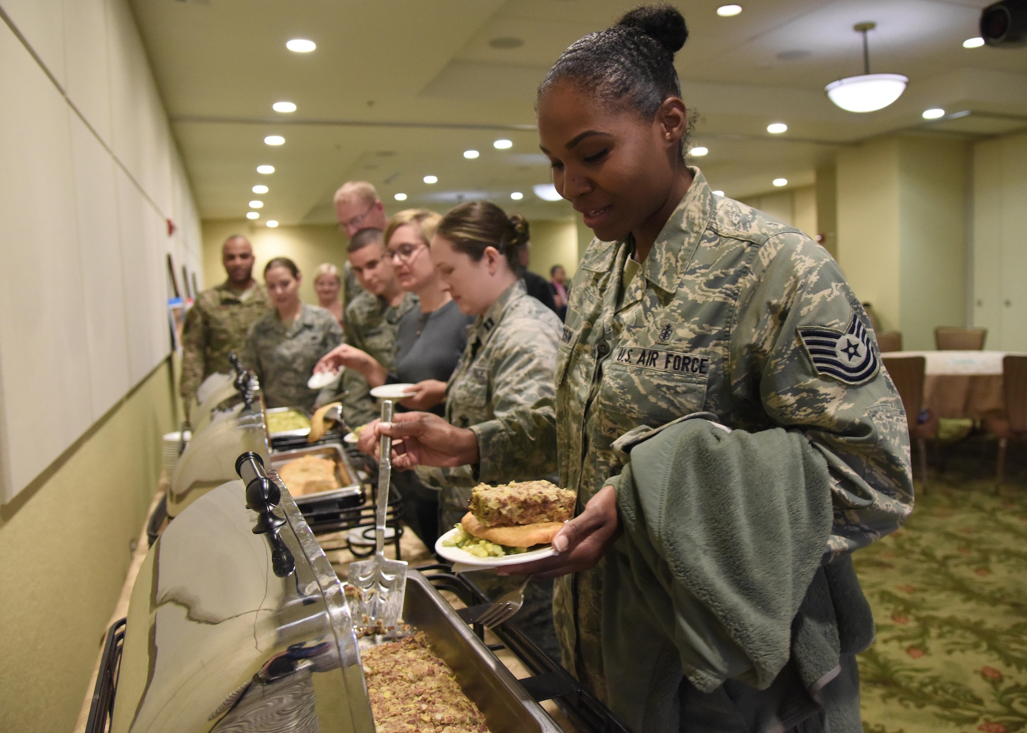U.S. Air Force Tech. Sgt. Esi Jackson, 81st Dental Squadron dental logistics NCO in charge, places a serving of poyha, a venison dish handed down from the Cherokee tribe, on her plate during the Native American Heritage Month Food Tasting at Keesler Air Force Base, Mississippi, Nov. 29, 2018. The event was held in celebration of Native American Heritage Month. (U.S. Air Force photo by Kemberly Groue)