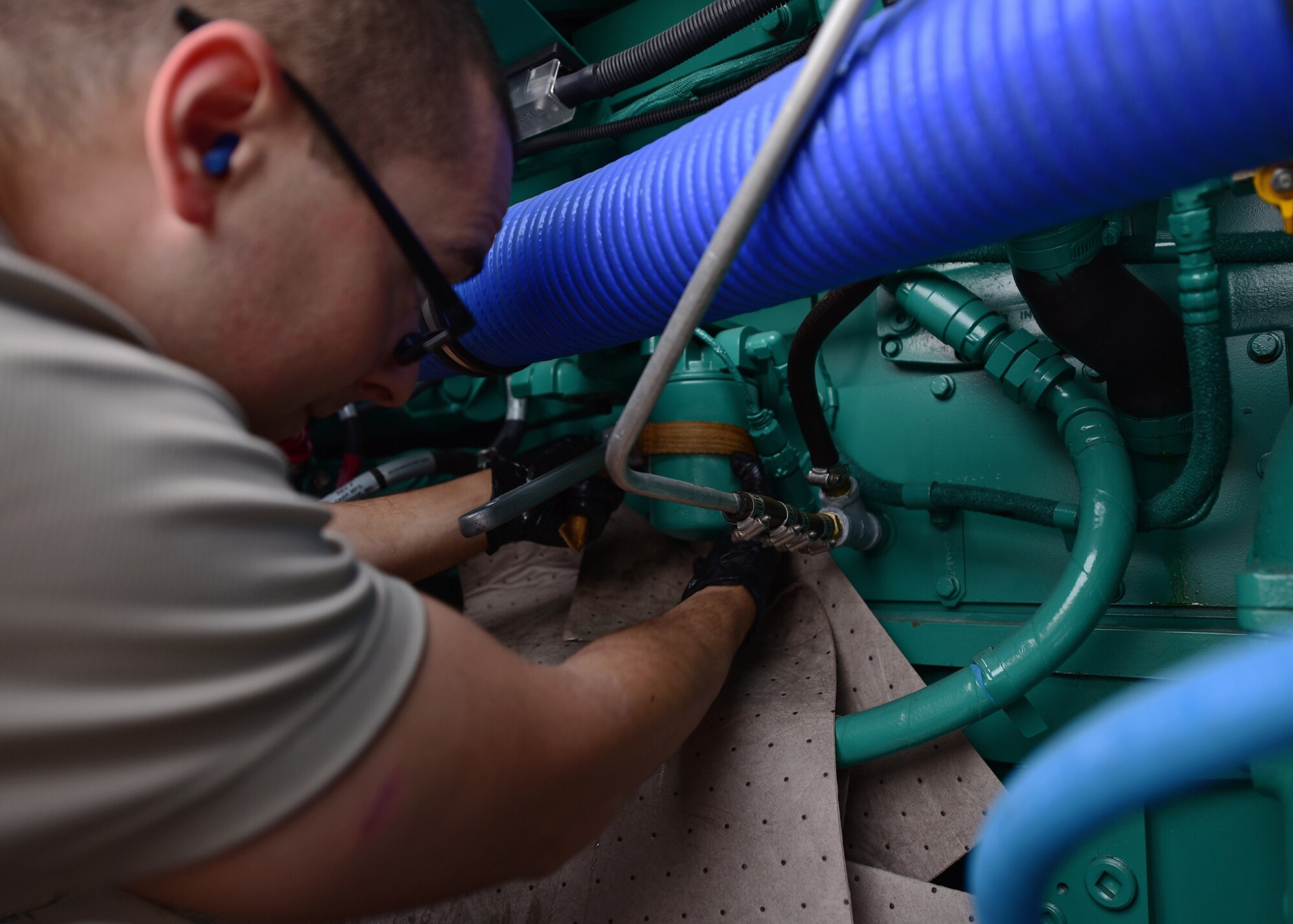 Staff Sgt. Joshua R. Olando, an electrical power production craftsman supporting the 325th Civil Engineer Squadron, uses an oil filter strap wrench to remove filters on a BPU 800 kilowatt high-voltage generator Nov. 30, 2018, at Tyndall Air Force Base, Fla. Bases from around the country sent Airmen and assets to aid in clean up and reconstruction after Hurricane Michael ravaged Tyndall Air Force Base. Olando is currently deployed from the 436th Civil Engineer Squadron at Dover Air Force Base, Del. (U.S. Air Force photo by Senior Airman Isaiah J. Soliz) Maintenance