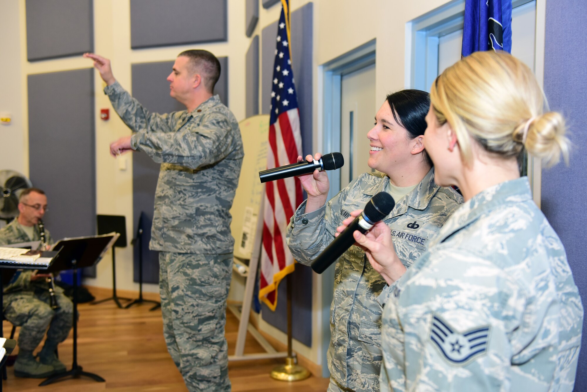 Tech. Sgt. Amy Chicavich (center) and Staff Sgt. Megan May (right), vocalists with the Air National Guard Band of the Northeast, and Maj. Joseph Denti (left), commander and conductor of the band, rehearse Nov. 17, 2018, for the band’s annual holiday concert. The concert is scheduled for Dec. 16 at the Auditorium of the Scottish Rite Cathedral, Harrisburg, Pennsylvania, at 3 p.m. and will feature the 35-piece wind-ensemble Concert Band performing several winter and holiday-themed songs. (U.S. Air National Guard photo by Tech. Sgt. Claire Behney/Released)