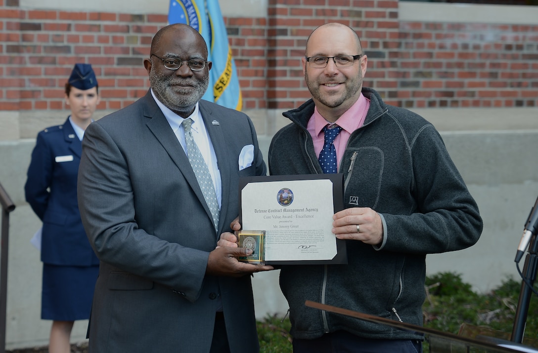 One man presents another man with an award