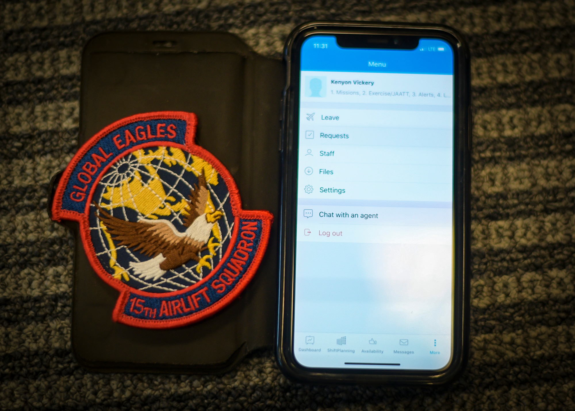 A 15th Airlift Squadron patch next to a smartphone with the squadrons scheduling application interface Nov. 30, 2018, at Joint Base Charleston, S.C. The 15th AS decided to employ an innovative and efficient way of relaying scheduling information to the flyers via a smartphone application.
