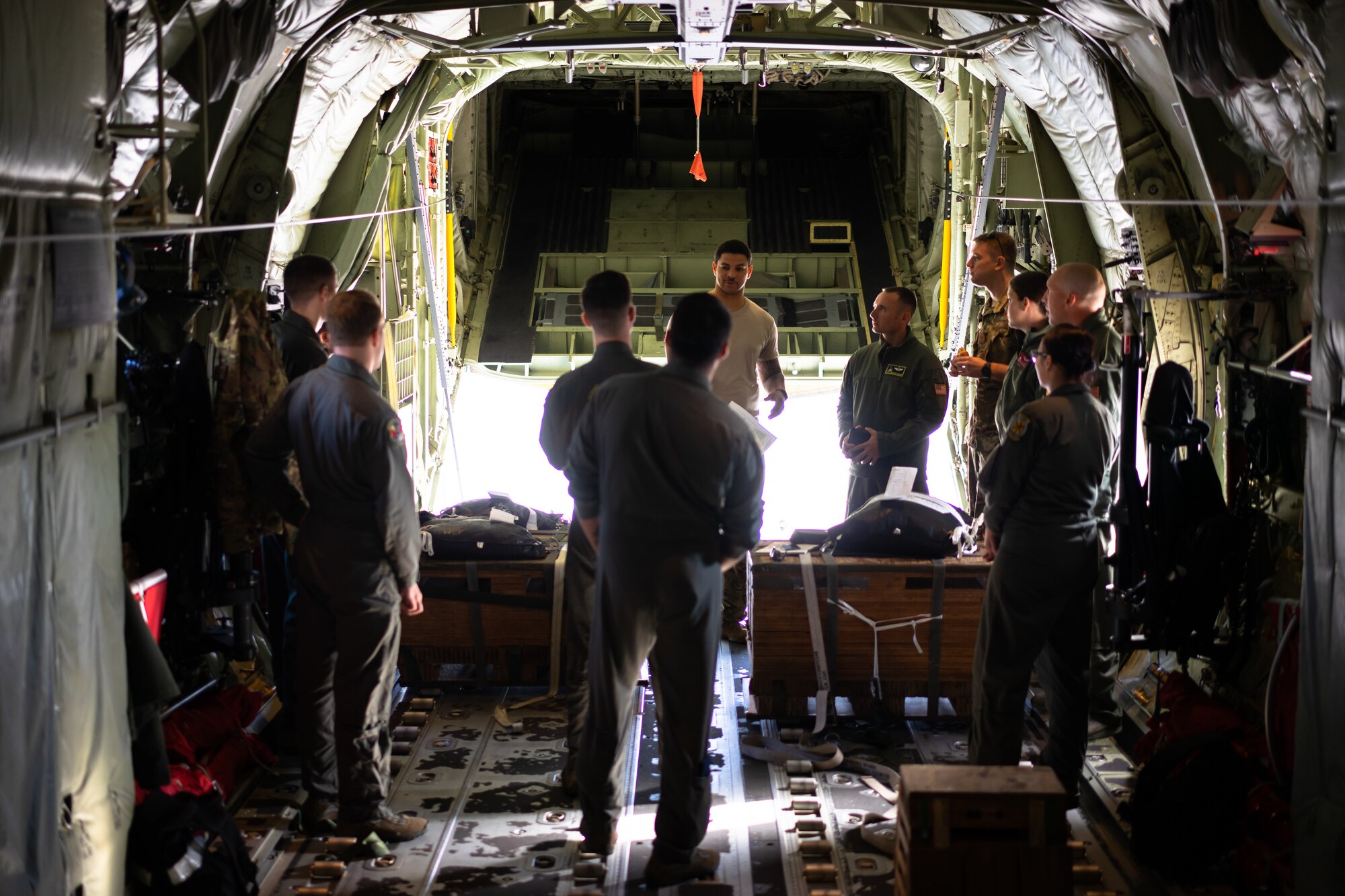 36th Airlift Squadron loadmasters discuss low-cost, low-altitude bundle rigging procedures in preparation for Operation Christmas Drop at Yokota Air Base, Japan Nov, 16, 2018. OCD is the longest running Department of Defense humanitarian airlift training operation and will provide nearly 25 tons of critical supplies to 56 Micronesian Islands this year impacting about 20,000 people. (U.S. Air Force photo by Tech. Sgt. Michael Smith)