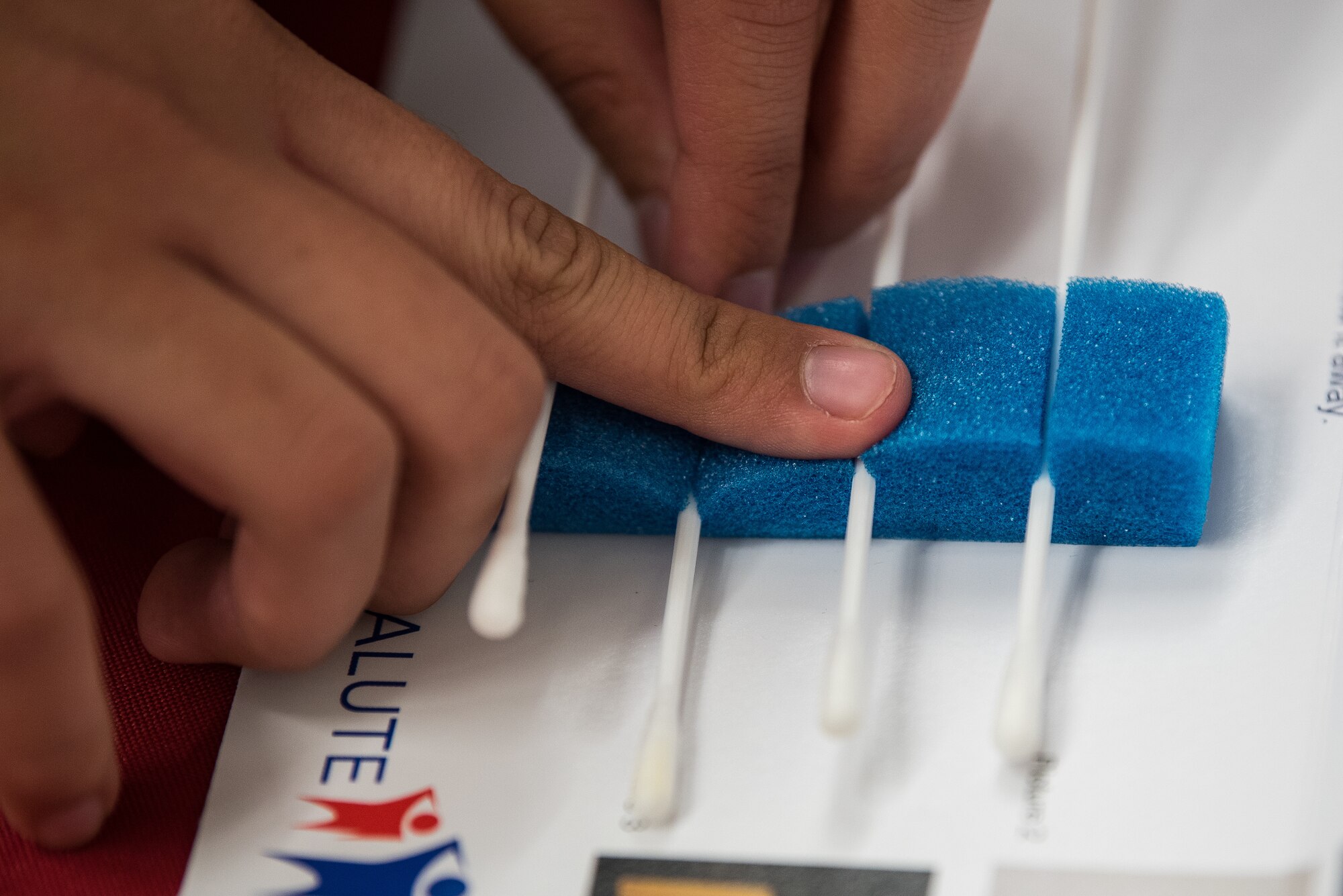 Airman 1st Class Jaqueline Ortega, 27th Special Operations Communications Squadron radio frequency transmission systems technician, inserts a cotton swab used to collect saliva into a carrier at Cannon Air Force Base, New Mexico, Nov. 30, 2018. The cotton swabs are analyzed to see if someone is a valid bone marrow donor. (U.S. Air Force photo by Airman 1st Class Vernon Walter)