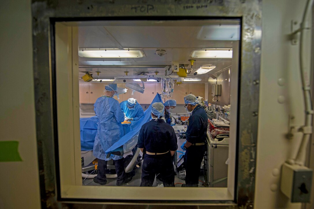 A medial team is seen performing surgery through a window.