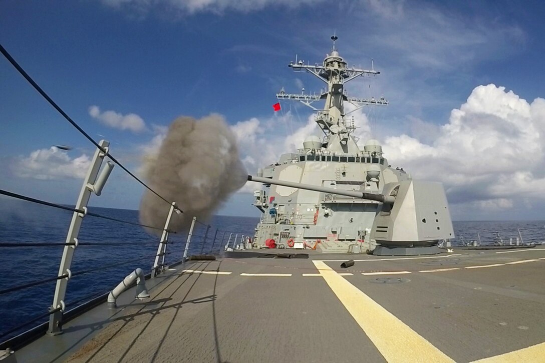 A machine gun on a ship fires.