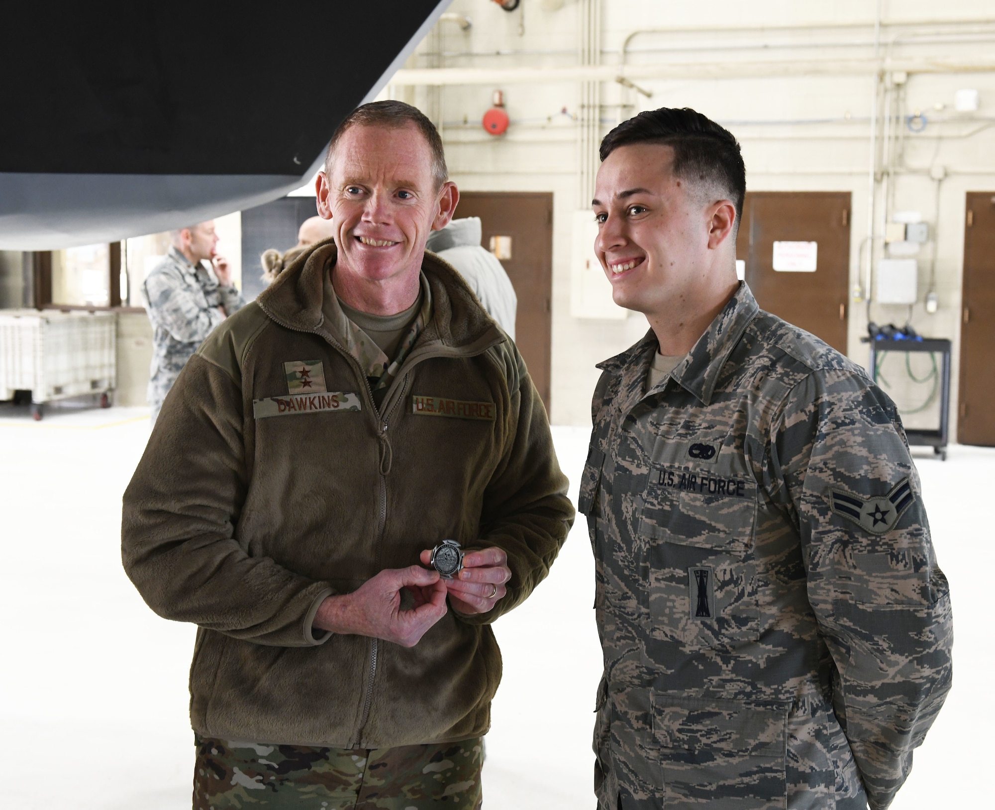 U.S. Air Force Maj. Gen. James Dawkins Jr., the 8th Air Force and J-GSOC commander, coins Airman 1st Class Kelsey Gray, a 28th Bomb Wing aircraft maintenance squadron weapons loader, while viewing a B-1B Lancer at Ellsworth Air Force Base, S.D., Nov. 13, 2018. Dawkins discussed the importance of taking care of people during his all call. (U.S. Air Force photo by Airman 1st Class Thomas I. Karol)