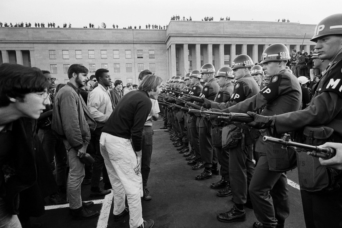 Army military police officers use weapons to block a crowd demonstrating against the Vietnam War outside the Pentagon, Va., Oct. 21, 1967.