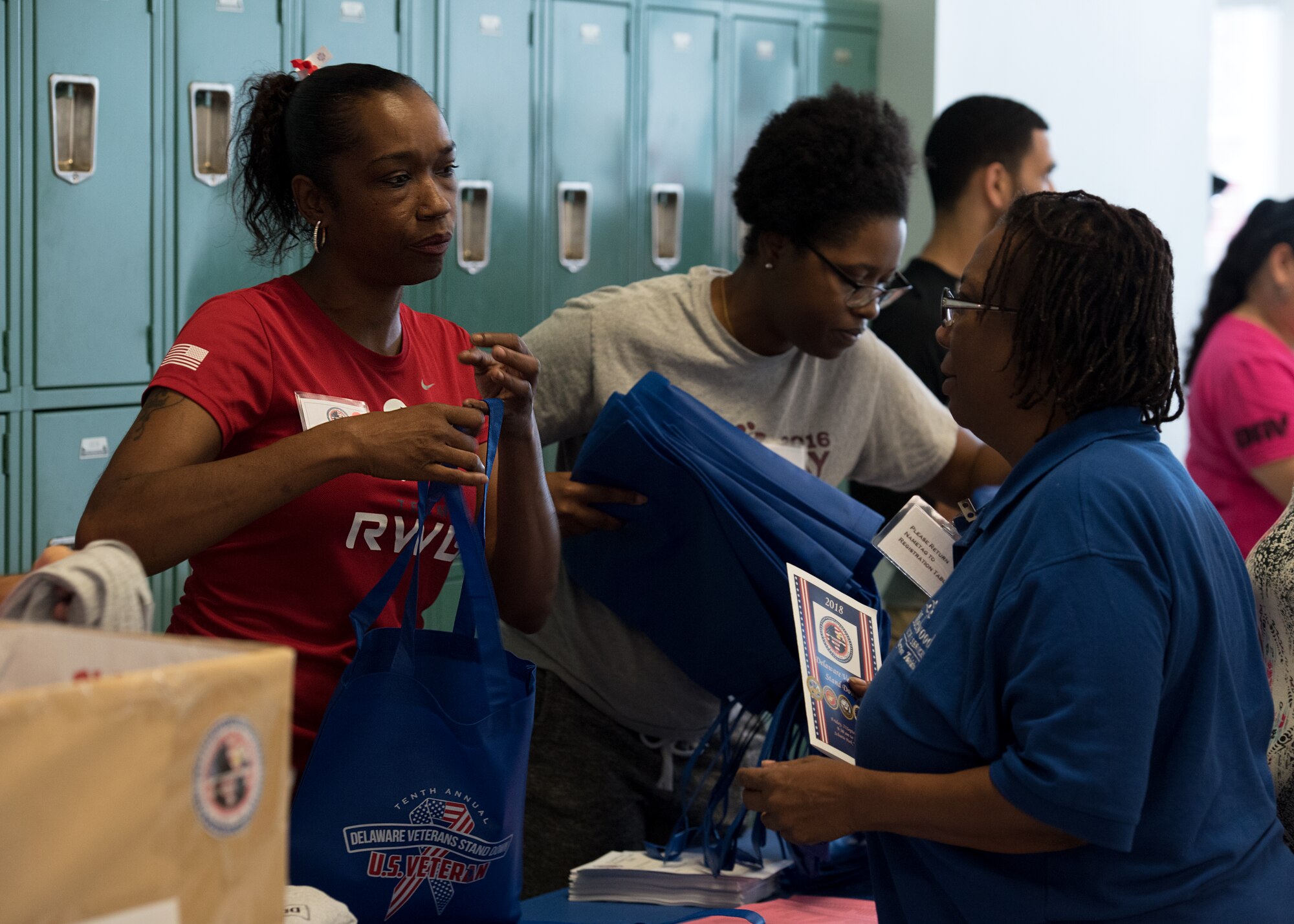 Master Sgt. Sonia Addison, the 512th Aircraft Maintenance Squadron’s NCO in charge of the commander support staff, gives out informational packets and t-shirts to military veterans at the 10th annual Delaware Veterans Stand Down Sept. 21, 2018, at Schutte Park in Dover, Delaware. Addison was one of more than 30 Dover Air Force Base, Delaware reservists who volunteered at the event. (U.S. Air Force photo by Staff Sgt. Zachary Cacicia)